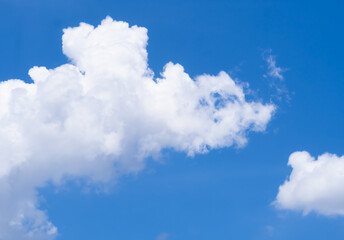 Blue sky with unusually shaped white clouds on a clear day, fluffy white clouds.