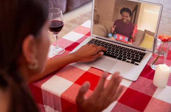 Multiracial young couple dating online through laptop on valentine day
