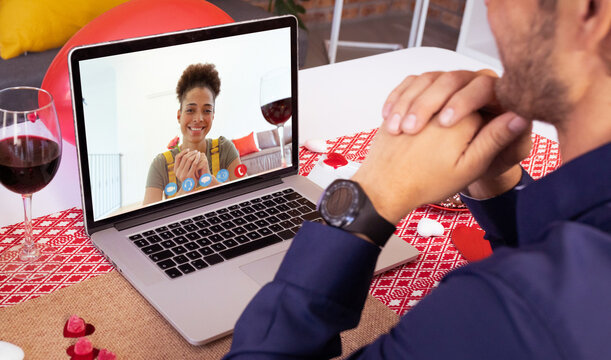 Smiling biracial young woman video calling with caucasian young man on laptop