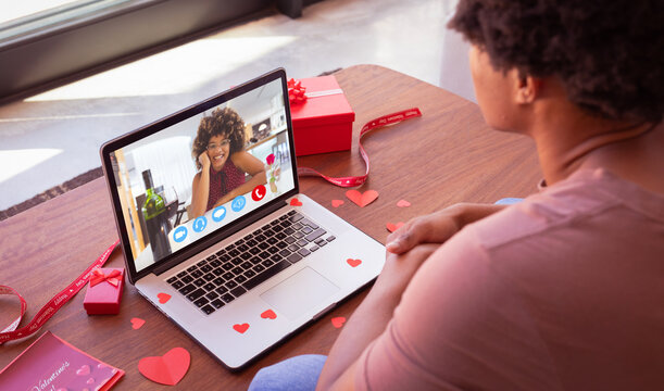 Biracial young couple celebrating valentine day online through laptop