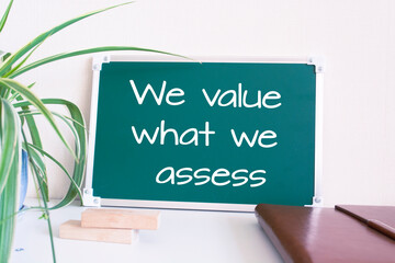 Text We value what we assess written on the green chalkboard
