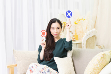 NGのプレートを持っている女性