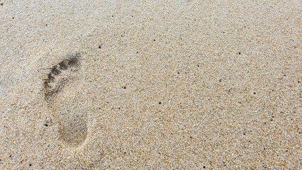 Foot print and sand at the beach background