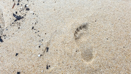 Fototapeta na wymiar Foot print and sand at the beach background