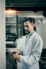 Engineer with tablet working at polymer factory