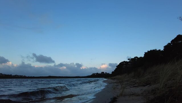 Man walking up a beach on a cold winters morning in Tasmania, Australia