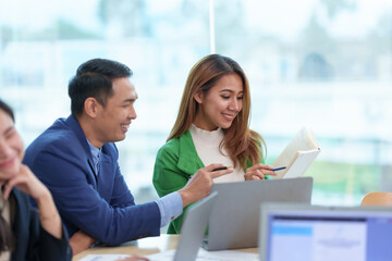 Group of Asian business people meeting to discuss and plan investment business and market analysis for business development There are data project plans for various analyzes and use a laptop computer.