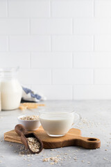 Oatmeal vegetable milk in a mug on the table with oatmeal in a bowl. 