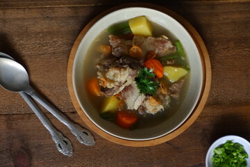 a bowl of beef ribs soup and vegetables
