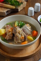 a bowl of beef ribs soup and vegetables