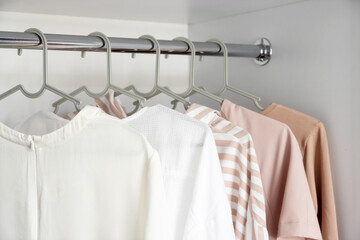 Clothes hanging on a clothes rack in a store or home closet.