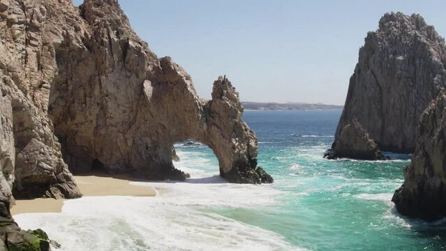 aerial drone shot of waves crashing on sea cliffs in Cabo San Lucas Mexico. waves crashing into rocky shoreline.
clear turquoise water. perforated sea cliffs. 4K videos.