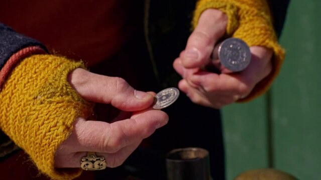 Examining a freshly minted coin made from a vintage Viking coin punch - isolated