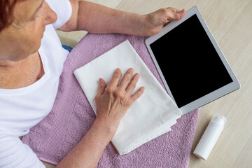 mockup, an elderly woman looks at a tablet, looking for information, copy paste