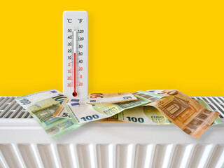 Euro banknotes on home heating radiator with thermometer. Energy crisis and expensive heating costs...