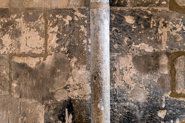 Cement and natural stone wall texture background with round column in foreground