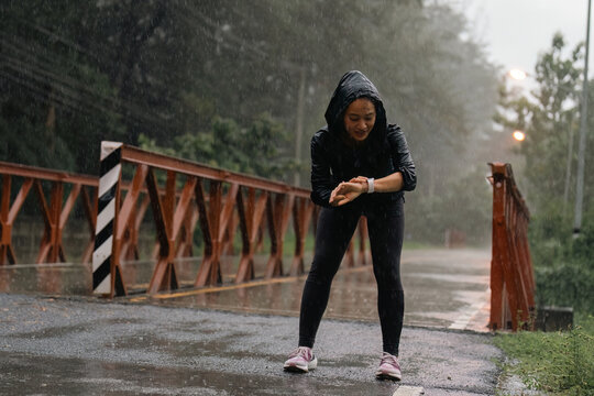 Asian ladies running in the rain she is tired