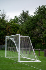 Soccer of football goal posts against dark trees background. Sport equipment. Selective focus.