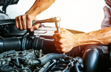 car service concept. engine repairing close up. mechanic hands are repairing car engine