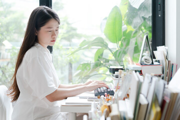 Asian woman typing on keypad