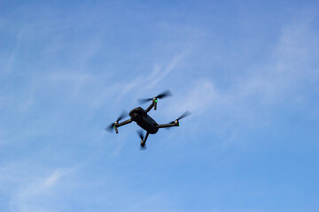 The quadcopter is flying in a blue sky.