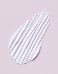 close-up cosmetic smear cream texture on pastel pink background	
