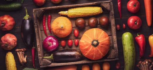close-up of fresh fruits and vegetables in a box on a flatline wooden table. assorted autumn harvest details