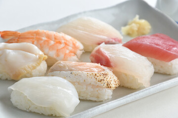 Fototapeta na wymiar Sushi Set nigiri sashimi and on white plate over white background-Jananese Food