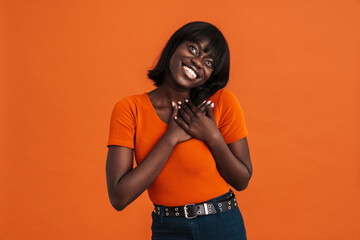 African woman pressing hands to chest in thankful gesture isolated