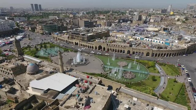 An aerial shot of the city of Erbil showing the ancient Erbil Citadel and the garden opposite the castle with water fountains and the popular market