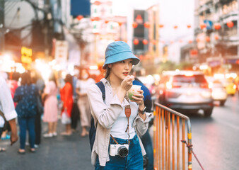Young adult asian foodie woman backpack traveller eating asia dessert at china town street food