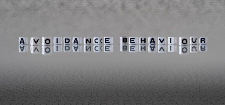 avoidance behaviour word or concept represented by black and white letter cubes on a grey horizon background stretching to infinity