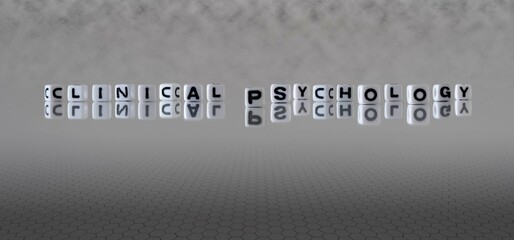 clinical psychology word or concept represented by black and white letter cubes on a grey horizon...