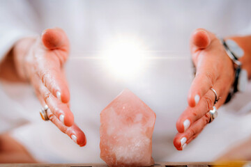 Self-awareness meditation concept. Emotionally aware person holding hands around energized crystal,...