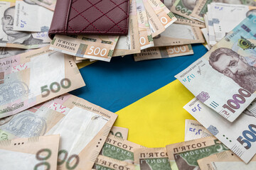 purse wallet with hryvnia on the background Ukrainian flag