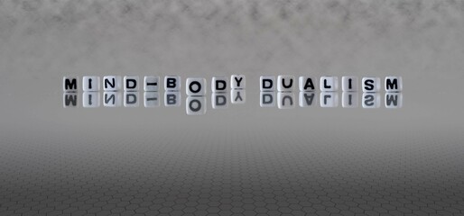 mind body dualism word or concept represented by black and white letter cubes on a grey horizon background stretching to infinity - obrazy, fototapety, plakaty