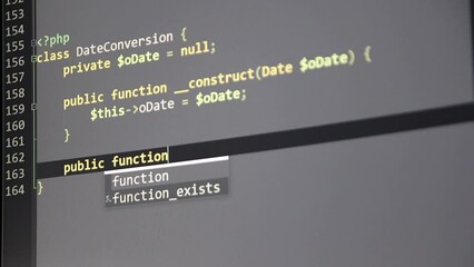 Typing PHP-code on screen by web developer and php developer shows computer screen with source code of website and server scripts for modern applications in secure object oriented programming language