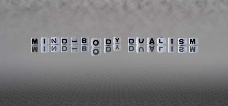 mind body dualism word or concept represented by black and white letter cubes on a grey horizon background stretching to infinity