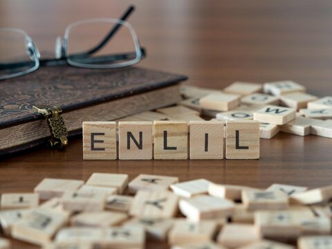 enlil word or concept represented by wooden letter tiles on a wooden table with glasses and a book