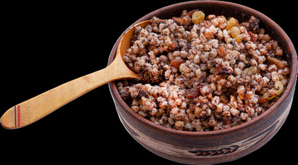 Kutia in a bowl with a wooden spoon. Boiled wheat with raisins, poppy seeds and nuts. Food for Christmas. Isolated.