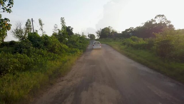 Following White Car Driving On The Road In Trimbakeshwar, Nashik, India. drone shot