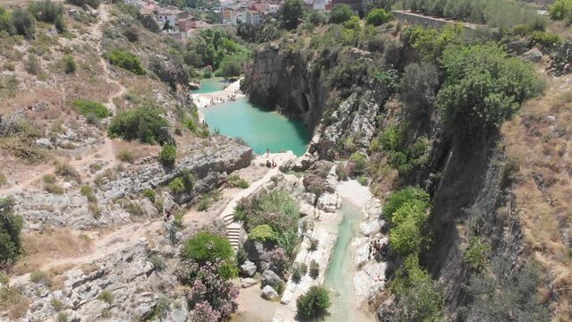 Bolbaite River, Valencia, Spain people enjoying a swim in river. Aerial view, tilt down.