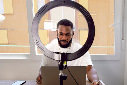 Young influencer with laptop vlogging at home