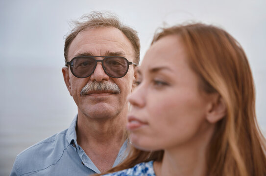 Senior man with sunglasses standing by woman