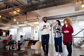 Young businesswomen talking to colleague in office asking for advice