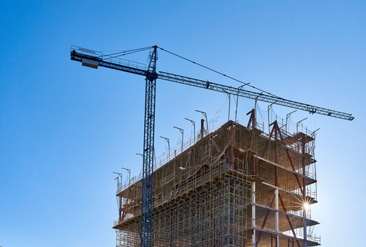 Crane standing in front of building under construction