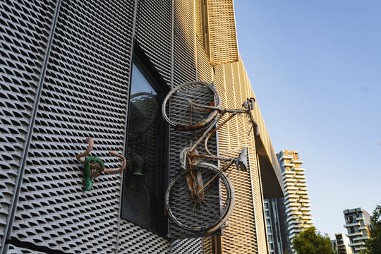 Old bicycle mounted near window of modern building