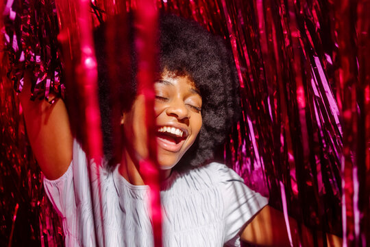 Carefree young woman amidst tinsels enjoying at party