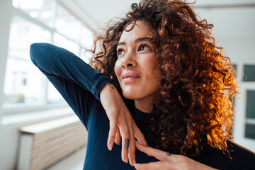 Smiling thoughtful woman with curly hair