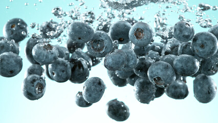 Blueberries pieces falling underwater on blue background.